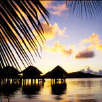 Silhouettes of overwater bungalows in Huahine, French Polynesia