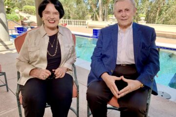 Debbie and Warner Lusardi sitting outside in front of their pool