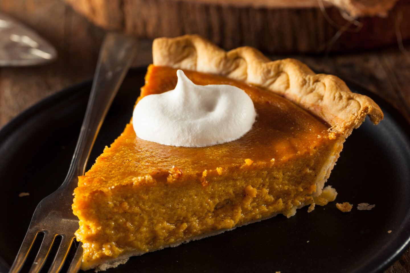 Delicious slice of pumpkin pie with a dollop of whipped cream