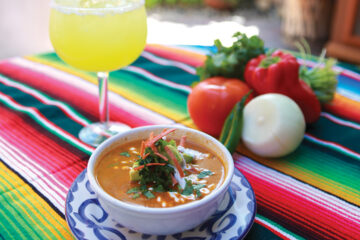 Diane Powers’ Roasted Corn Enchilada Soup on colorful tablecloth with margarita