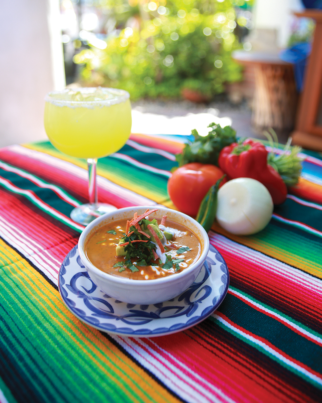 Diane Powers’ Roasted Corn Enchilada Soup on colorful tablecloth with margarita