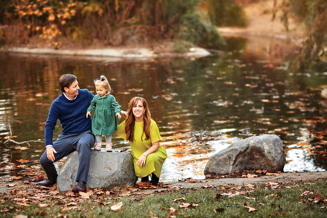 Matt and Emily Bowman with daughter Hannah in front of a tranquil lake
