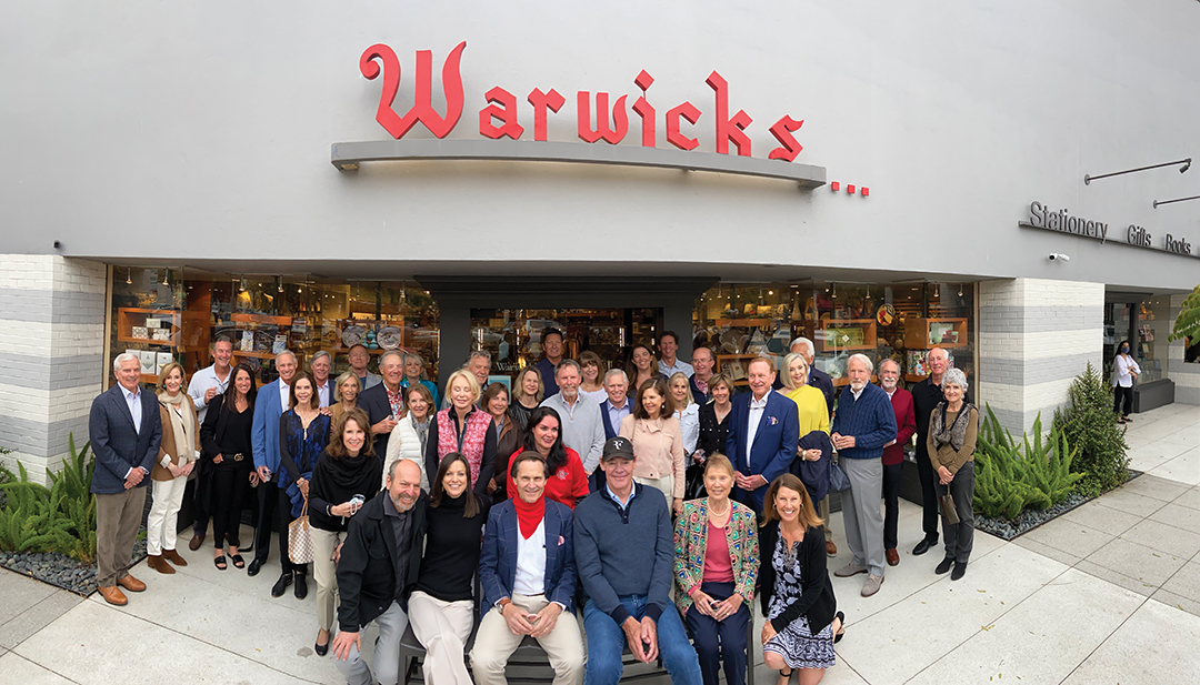 Nancy Warwick (front row, second from left), Steve Avoyer (with red scarf), and Jack McGrory (front, center), along with the group of investors who purchased the Girard Avenue building in which Warwick’s is located