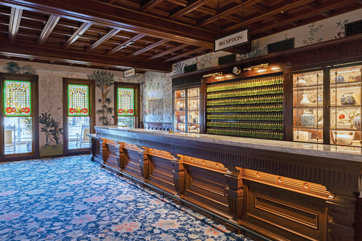 The front desk area with recreated stained-glass and Victorian-inspired wallpaper hand-painted in England