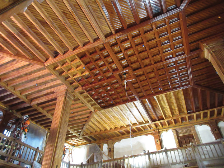 The lobby ceiling during removal of non-historic coatings. The restored ceiling was later re-stained and shellacked