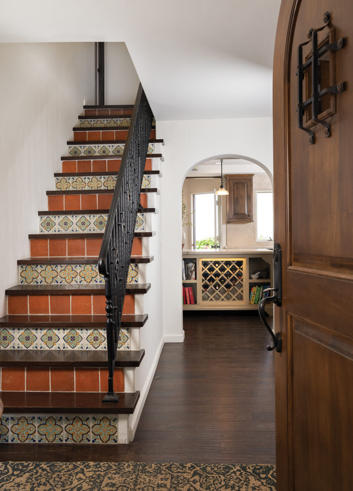 The staircase, once carpeted and with floral wallpaper, was redesigned with wrought iron railings and Mexican tile