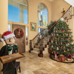 In the foyer, Dee decorated the Christmas tree with dozens of Christopher Radko ornaments, and a wooden butler stands at the ready