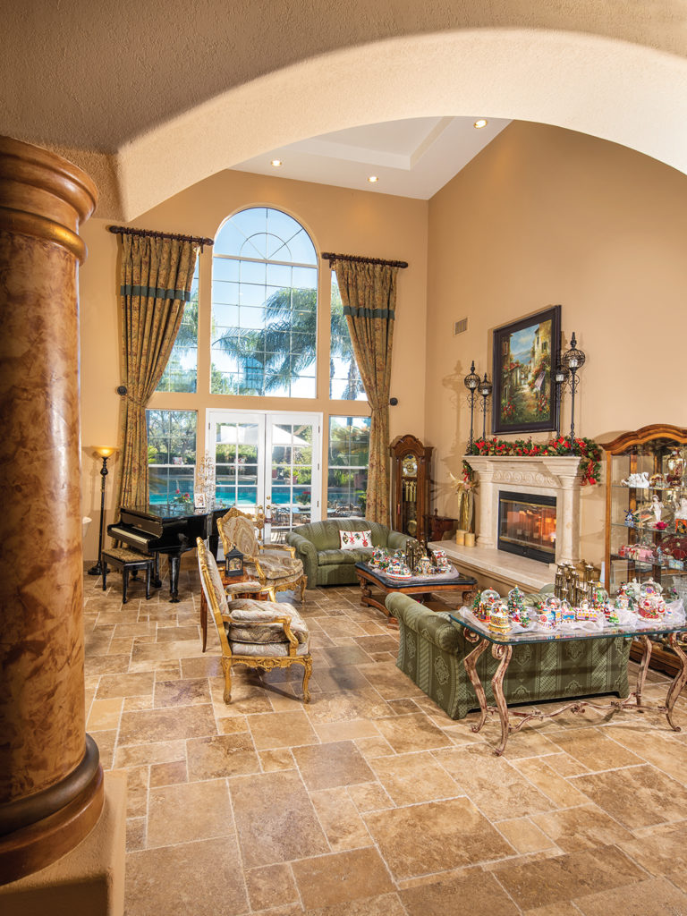 A fireplace warms the formal living room which opens onto a backyard patio, pool, and barbecue area