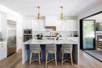 Designers updated the kitchen with a quartz waterfall-style island, counter stools, and twin pendant lights