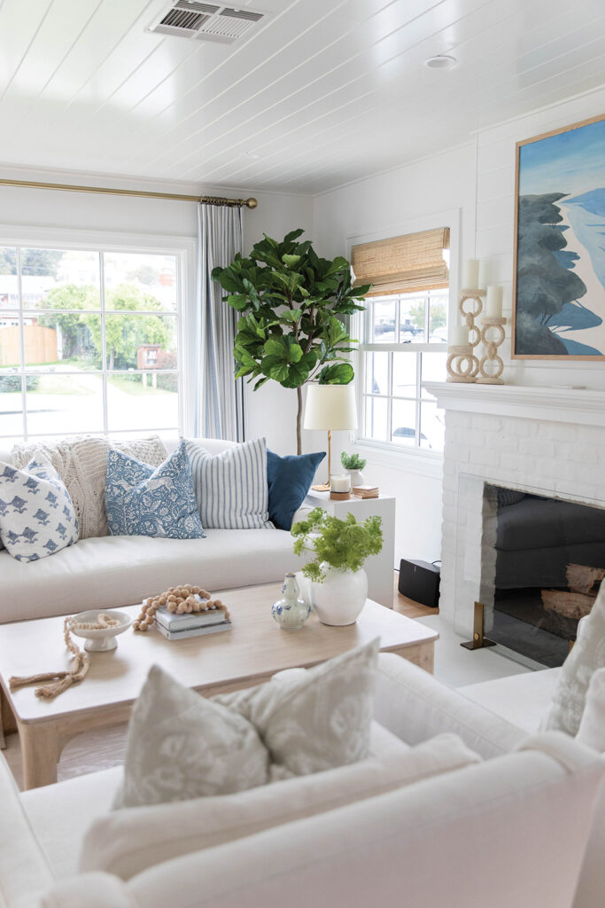 AGK Design Studio furnished a living room with a sofa and chairs from Serena & Lily, a coffee table from Noir Furniture, and artwork from Anthropologie