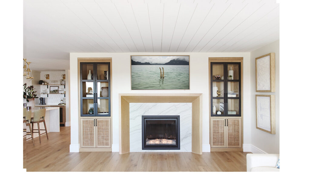 In Del Mar, a marble fireplace surround is flanked by custom hutches from inSIDE by Savvy, tying in the family room and kitchen for a cohesive look