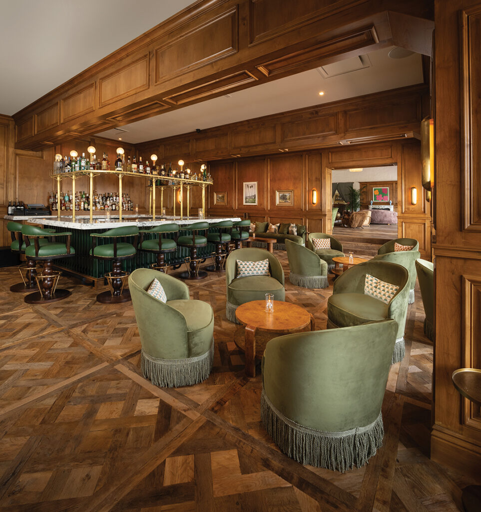 Bing’s Bar, named in homage to crooner and movie star Bing Crosby, has custom wood paneling, a marble countertop, and an overhead liquor rack. Green velvet couches and lounge chairs provide comfortable seating
