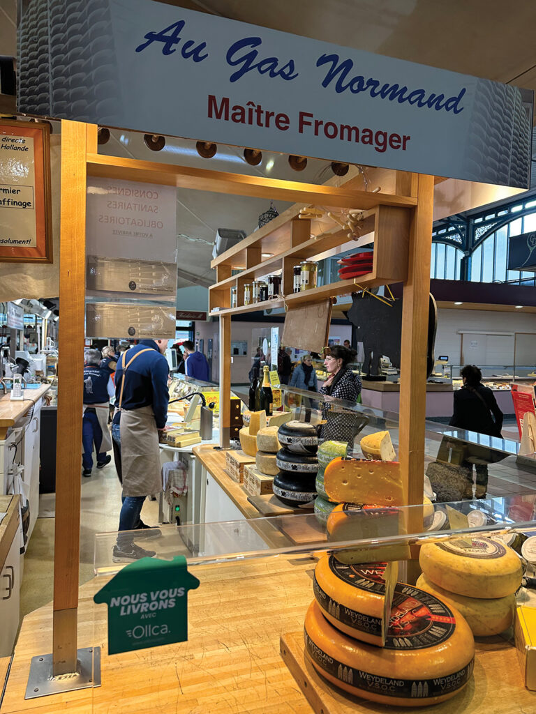 A cheesemonger in the Central Indoor Market Hall in Dijon. With myriad shops and food stalls, roaming this mammoth marketplace and passing sellers of local produce and other foodstuffs is absolute fun