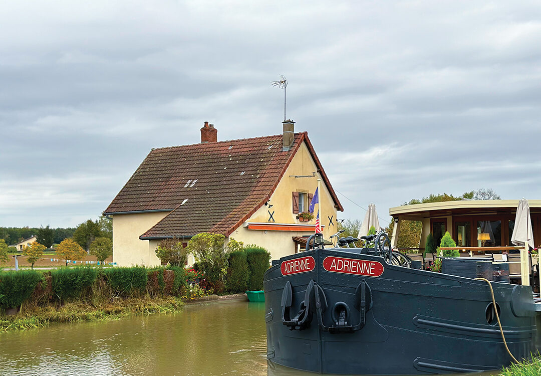 Adrienne eases past the lock keeper’s cottage after locking through at Fontaines-sur-Saône in Eastern France
