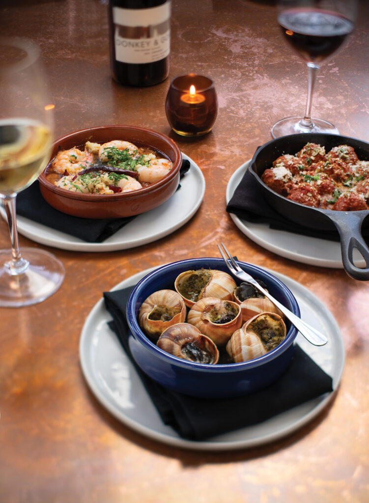 House favorites for sharing include (clockwise from top left) Gambas al Ajillo, Albondigas, and Caracoles