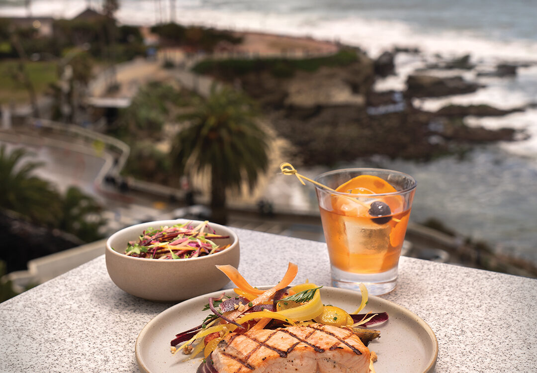 Wild Isles Salmon: Indian spice aioli, kumquats, roasted baby carrots, Marcona almonds (center) with Crab Salad: Valencia Pride mango, carrots, sprouts, radish, citrus dressing, and a Premium Old Fashioned