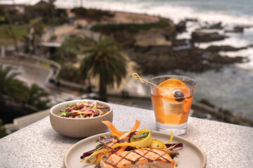 Wild Isles Salmon: Indian spice aioli, kumquats, roasted baby carrots, Marcona almonds (center) with Crab Salad: Valencia Pride mango, carrots, sprouts, radish, citrus dressing, and a Premium Old Fashioned