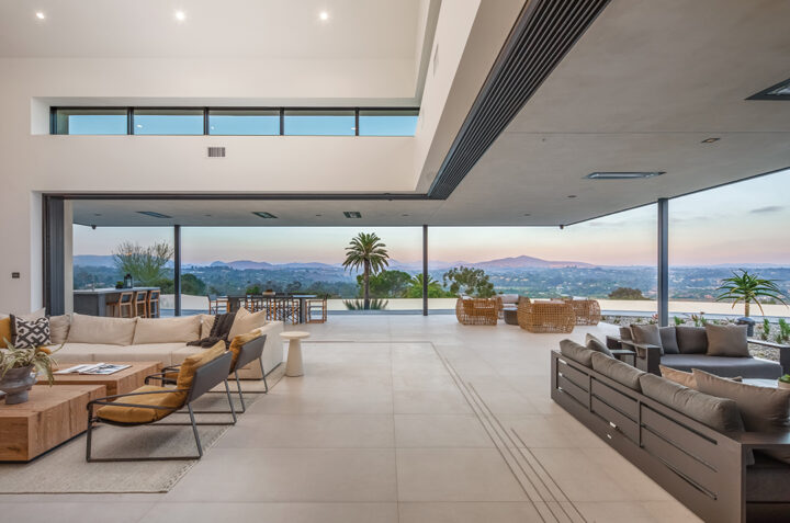 Floor-to-ceiling custom glass windows throughout the home bring the outdoors in and offer dazzling views. Interior furnishings are by Ruta Designs
