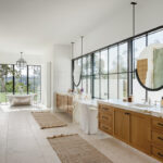 The master bath has twin counters and mirrors, a capacious shower, and a soaking tub with a view
