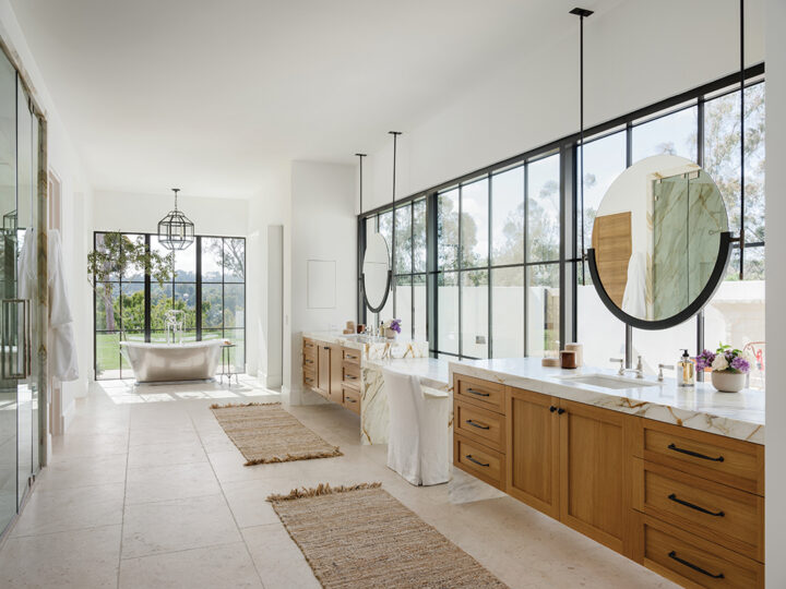 The master bath has twin counters and mirrors, a capacious shower, and a soaking tub with a view