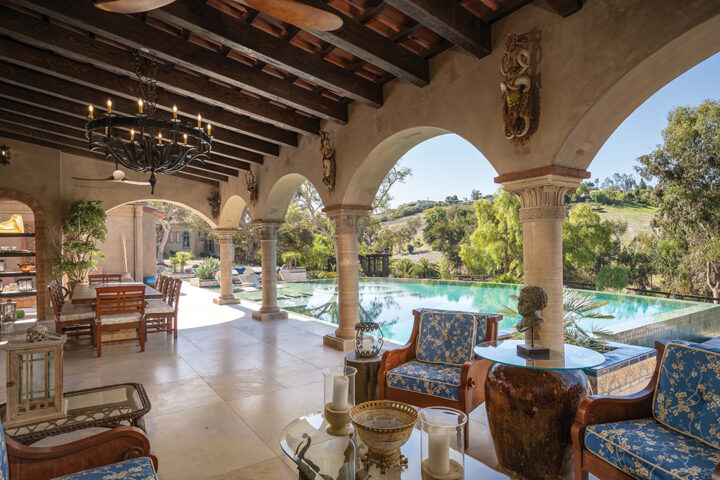 The infinity-edge swimming pool off the outdoor living room overlooks the rolling hills of Rancho Santa Fe
