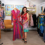 Roya Parviz, wearing a brightly patterned dress by Renee’ Dehry, shows off a colorful design at Satori Collective in the Cedros Design District