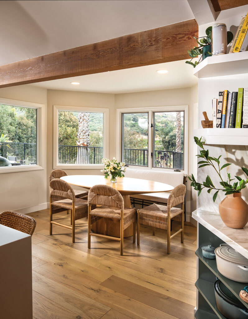 A dining area in the kitchen offers views of the palm trees and eucalyptus in the expansive backyard. Chairs are from Crate & Barrel and the custom breakfast table is from Jantzen Furniture on Etsy