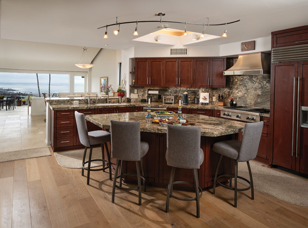 The open, light-filled kitchen has alderwood cabinets from CCS Cabinets and gleaming granite counters