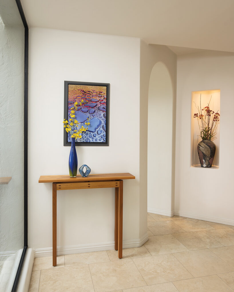 Steve, a talented photographer and furniture maker, crafted the hall table. Above the table is his striking photo of rain drops on his wife’s car