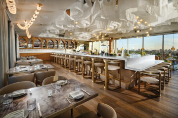 erched high above the city, with sweeping views of the San Diego coastline, Communion’s interior features an ivory fabric ceiling providing whimsical “cloud cover”