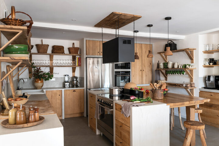 The kitchen was designed with the help of a chef friend to optimize its ergonomics. Custom-built with concrete and raw wood, it blends professional-grade equipment with a warm aesthetic, including a butcher block sourced from an old Bayonne butcher shop