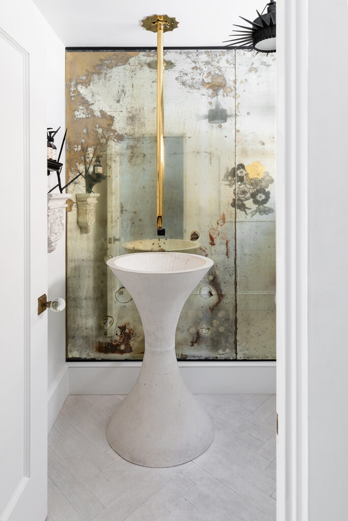 Garden Variety? For a powder room sink, Baumgart took inspiration from a garden planter designed by Swiss furniture designer Willy Guhl. When she couldn’t find authentic looking antique glass, Baumgart and her son took matters into their own hands to produce an “aged” mirror that now fills the wall of a powder bathroom