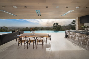 The patio overlooking the 80-foot infinity pool has spaces for lounging, dining, and cooking in the outdoor kitchen