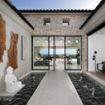 The dramatic entryway flanked by water features leads to the open living room and kitchen