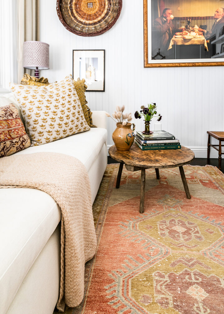 The office features a sofa bed from West Elm, pillows from The Shop Granite Bay, a coffee table from Juxtaposition Home, a desk lamp by Schoolhouse, and a purple lamp from Magnolia Mews with a custom lampshade by Lamp Shades Unlimited