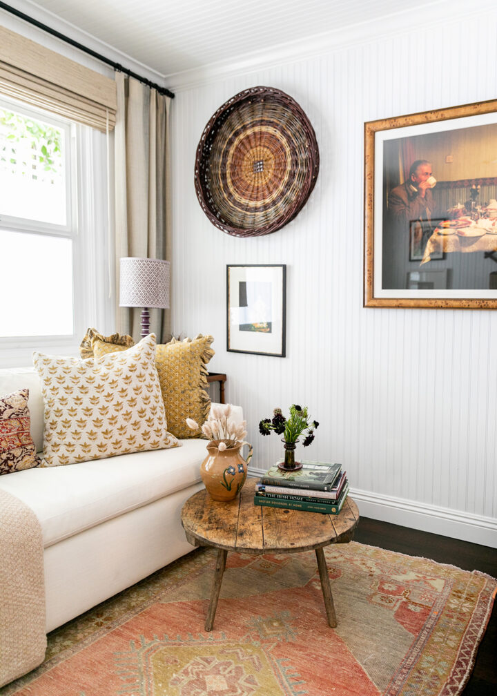 The office features a sofa bed from West Elm, pillows from The Shop Granite Bay, a coffee table from Juxtaposition Home, a desk lamp by Schoolhouse, and a purple lamp from Magnolia Mews with a custom lampshade by Lamp Shades Unlimited