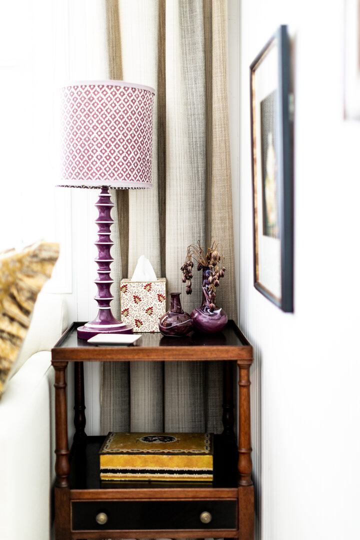 The office features a sofa bed from West Elm, pillows from The Shop Granite Bay, a coffee table from Juxtaposition Home, a desk lamp by Schoolhouse, and a purple lamp from Magnolia Mews with a custom lampshade by Lamp Shades Unlimited