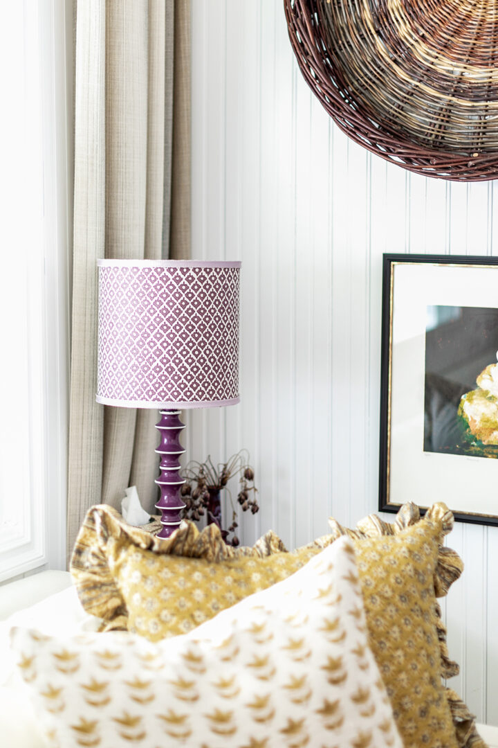 The office features a sofa bed from West Elm, pillows from The Shop Granite Bay, a coffee table from Juxtaposition Home, a desk lamp by Schoolhouse, and a purple lamp from Magnolia Mews with a custom lampshade by Lamp Shades Unlimited