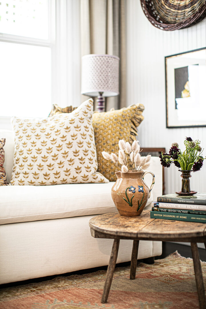 The office features a sofa bed from West Elm, pillows from The Shop Granite Bay, a coffee table from Juxtaposition Home, a desk lamp by Schoolhouse, and a purple lamp from Magnolia Mews with a custom lampshade by Lamp Shades Unlimited