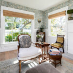 For a cottage renovation on Waverly, Mariucci tapped the spirit of the English seaside for her expat client. Here, a sweet sitting room is made more dramatic by the reclaimed mirrored barn doors that open onto it. Wallpaper is by Schumacher; antique chairs are given new life with fabric by Kravet and Perennials. Both ottomans, nesting tables, and accessories are from Girard Avenue Marketplace