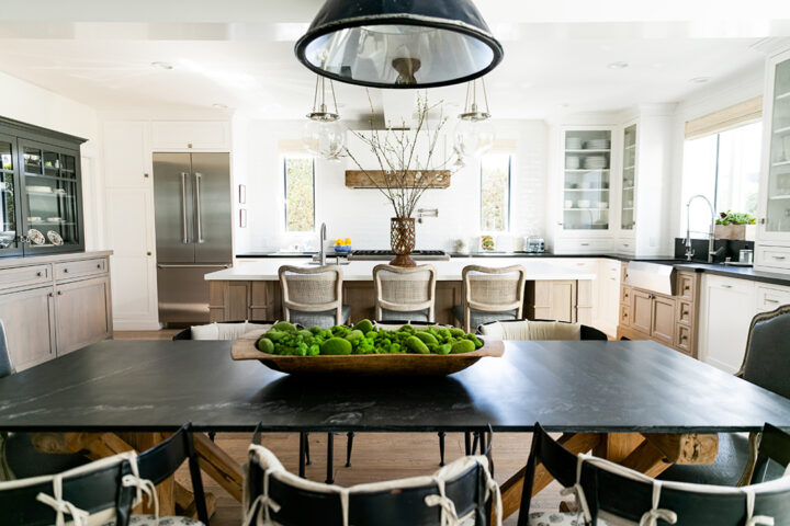 The kitchen and family room feature lighting by Rejuvenation and Essentials for Living bar stools with Perennials fabric. The island is Silestone Zeus White Suede finish and perimeter counters are Absolute Black Honed granite. Range and refrigerator are by Thermador