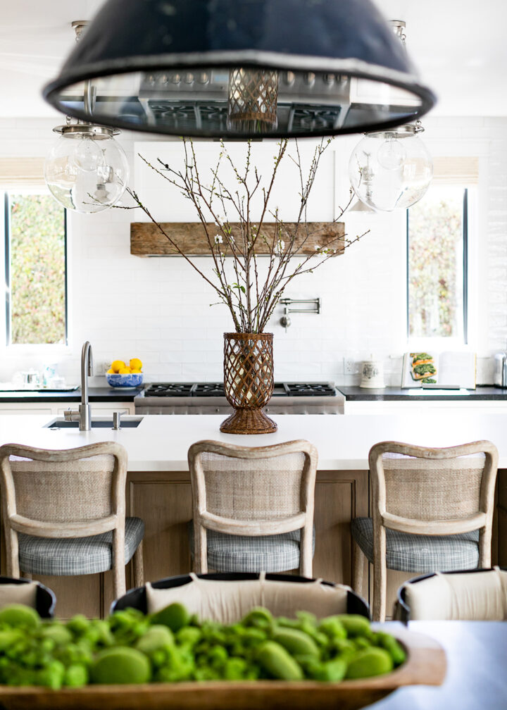 The kitchen and family room feature lighting by Rejuvenation and Essentials for Living bar stools with Perennials fabric. The island is Silestone Zeus White Suede finish and perimeter counters are Absolute Black Honed granite. Range and refrigerator are by Thermador