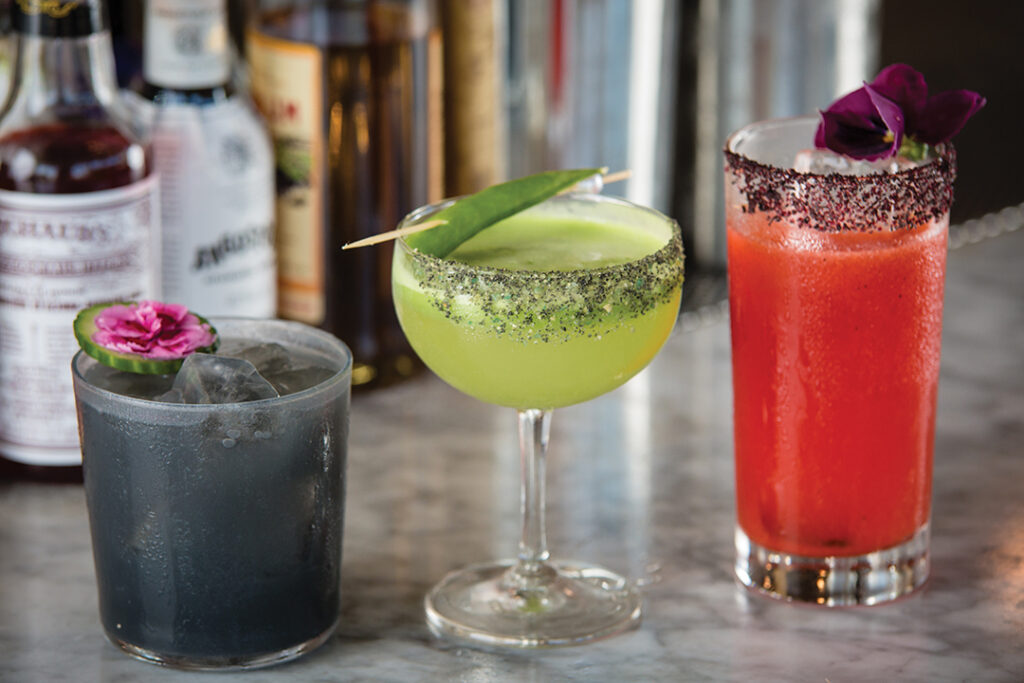 Signature cocktails include the “Dark Horse” (Tequila, Aloe, Lo-fi Vermouth, Smoked Salt, Orgeat, Lime, Cucumber, Activated Charcoal), “Lost In Translation” (Gin, Aquavit, Alpe Genepy, Snap Pea, Lime, Wasabi), and “Ruby Revival” (Blanco Tequila, Hibiscus Select, Red Bell Pepper, Grapefruit, Lime, Soda)