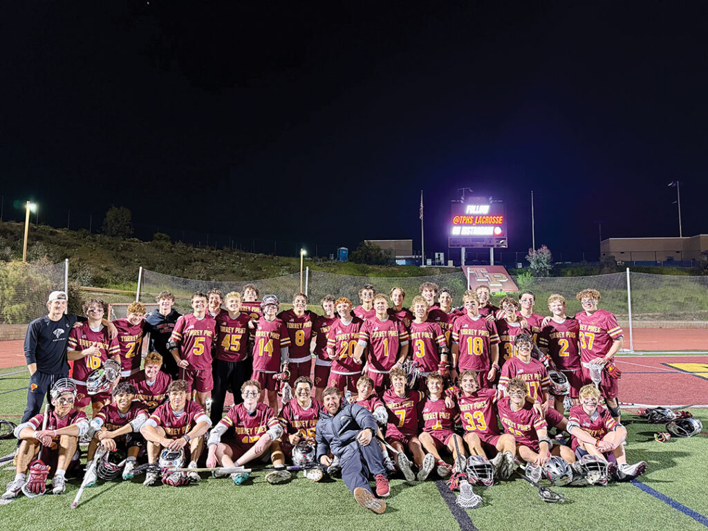 Coach Jono Zissi (center, in blue) with the Torrey Pines High School Lacrosse Team