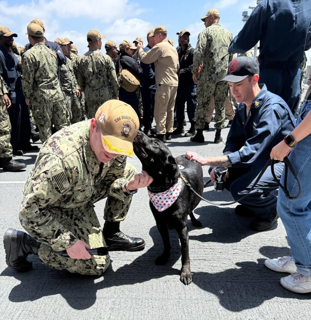 Raider gives kisses to Captain Ryan P. Conole, Executive Officer of the USS Makin Island