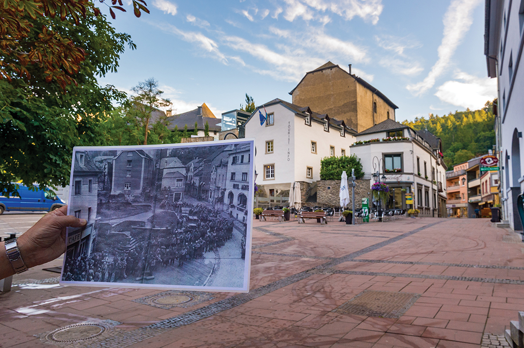 In Clervaux, a local guide shows visitors a World War II-era photo of the town square