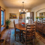 The dining room features vintage furniture, curtain finials, and a chandelier salvaged from the couple’s families. It also displays the couple’s prized collection of plein art