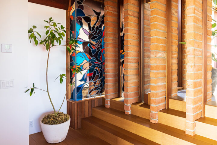 An Organic Origin Story: The Kellogg-Hubbell Partnership The creative collaboration between Kellogg and artist James Hubbell is on full display at 3016 Rogers. Hubbell’s wrap-around stained glass is contoured against Kellogg’s linear brick. The rhythm of colored light echoes the waves below