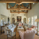 The airy living room opens onto a patio and swimming pool and features a mix of modern pieces, antiques, and flea market finds