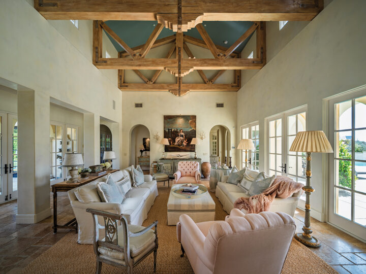 The airy living room opens onto a patio and swimming pool and features a mix of modern pieces, antiques, and flea market finds